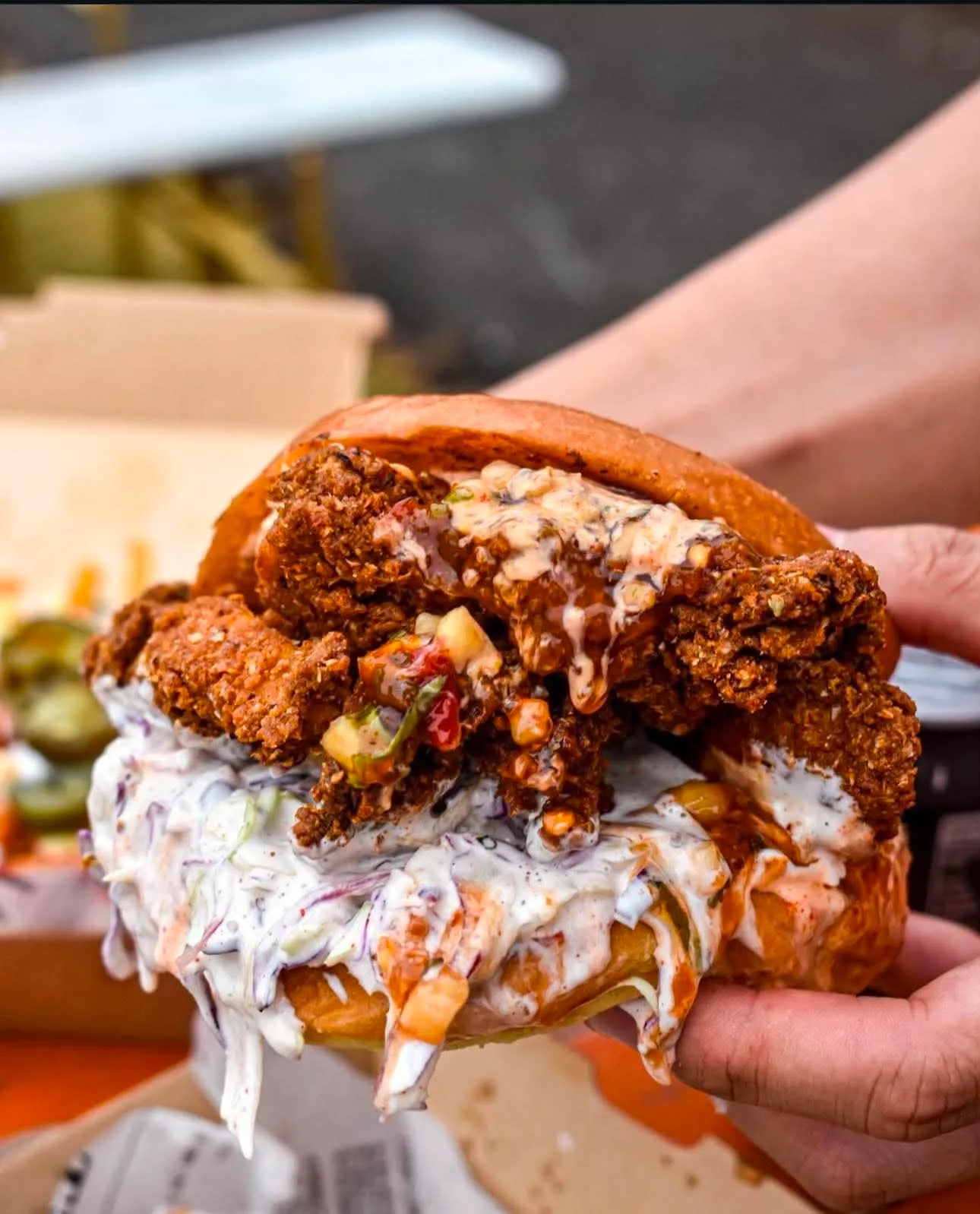 Burger It fried chicken burger held in front of the truck