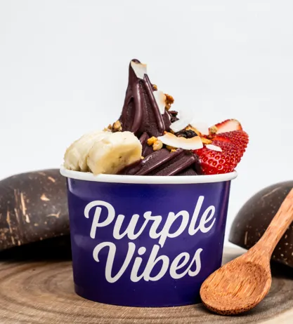 A loaded Purple Vibes açaí bowl topped with banana, strawberry, coconut and granola